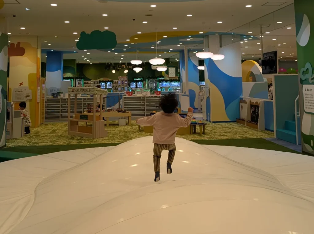 ちきゅうのにわ東戸塚店のふわふわ遊具で飛び跳ねる子ども