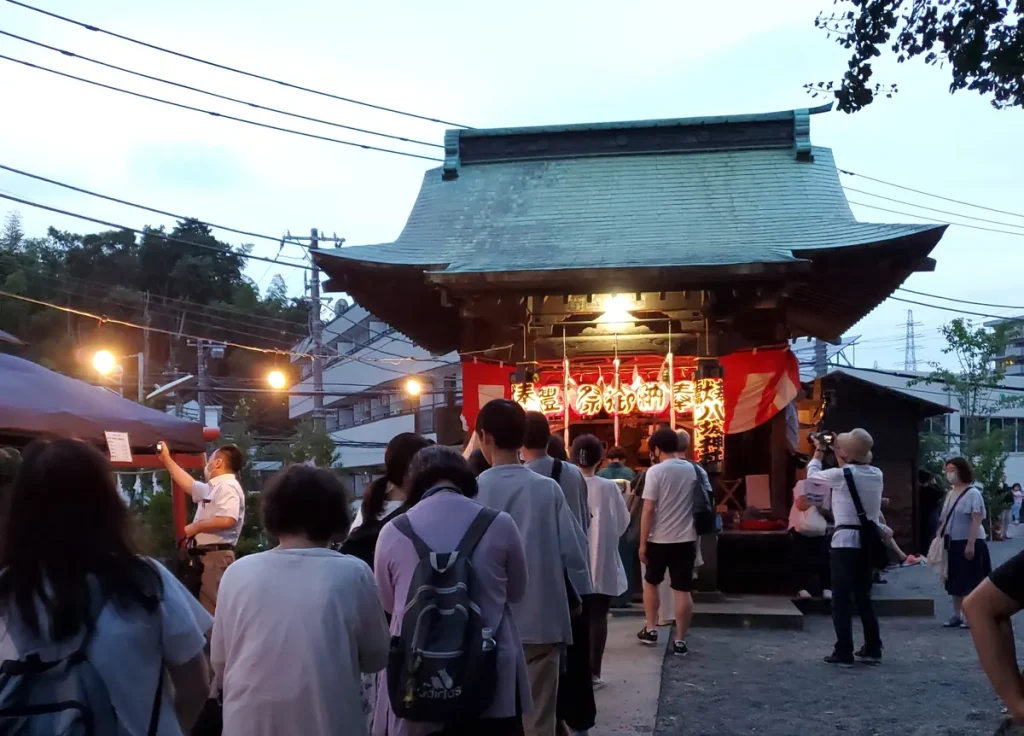提灯に照らされた夕暮れの八坂神社と参拝に並ぶ人々