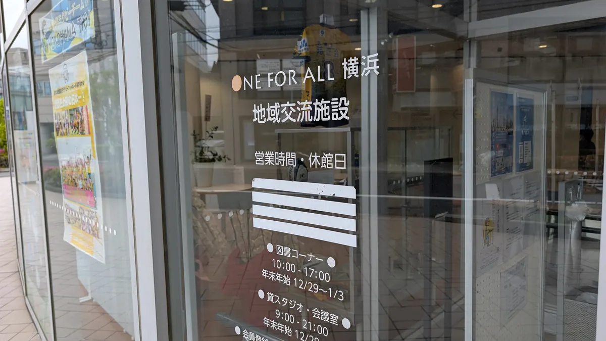 ONE FOR ALL横浜 地域交流施設の入口｜ガラスドアに営業時間と休館日が表示
