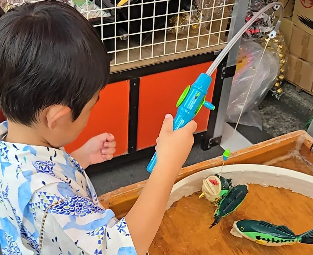 とつか夏まつりの縁日｜浴衣の子どもが魚釣りを楽しむ様子