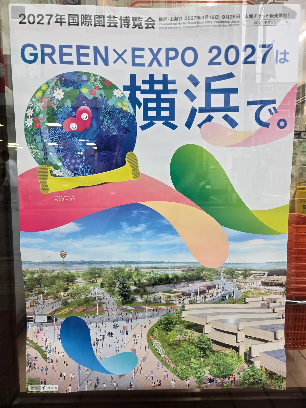 街なかに貼られた横浜花博GREEN×EXPO 2027のポスター|「横浜で。」のコピーとトゥンクトゥンク、会場のイメージ図