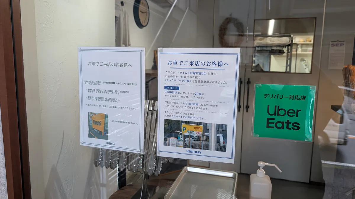 HORIDAY入口の掲示｜提携駐車場とUber Eats対応の案内