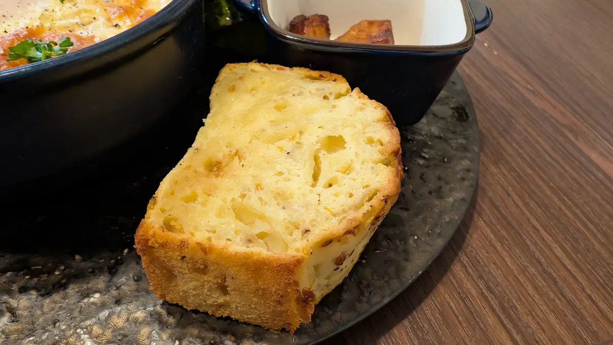 ランチに付いてくるケークサレの断面。きつね色の表面で、生地の中に具材が混ざっている