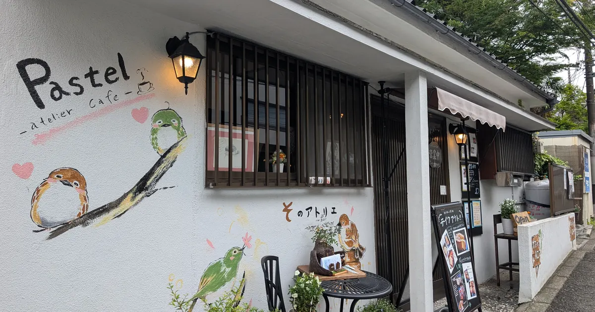 アトリエカフェパステルの外観。壁に店名ロゴと小鳥のイラストが描かれた戸塚町の古民家カフェ